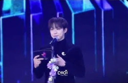 An artist giving an acceptance speech at the D Awards podium